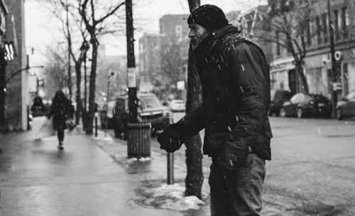 Man standing on snow covered tree