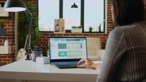 Midsection of woman using laptop at office