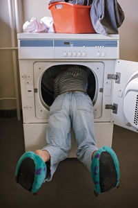 Teenage girl using common laundry to save resources and money. sustainability and environment care