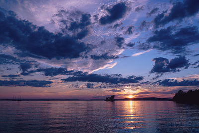 Scenic view of sea against dramatic sky during sunset