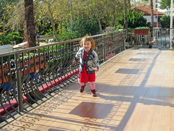 Full length of girl walking by railing