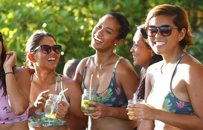 Friends in bikini enjoying drinks at party