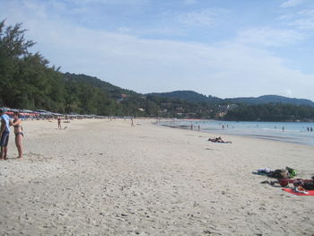 People at beach against sky