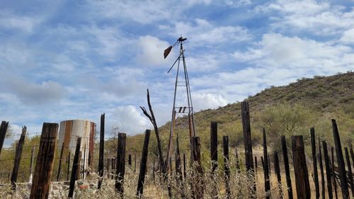 Panoramic view of wooden posts on field against sky