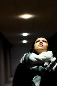 Low angle view of woman at illuminated cross