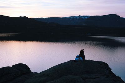 Silhouette man standing on mountain against sky