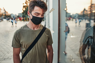 Portrait of young man standing in city