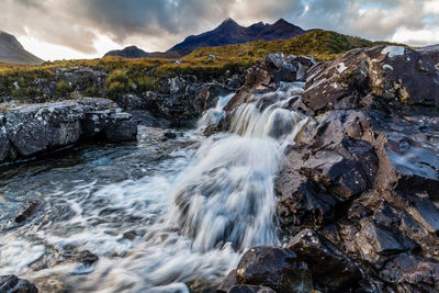 Scenic view of waterfall against sky