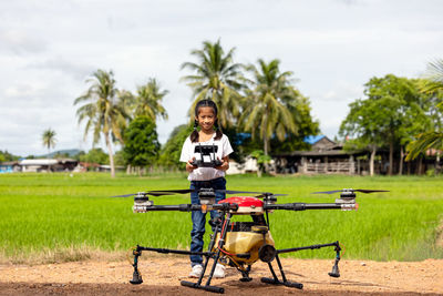 Agriculture farmer girl holds control to view a report on rice agriculture field,.