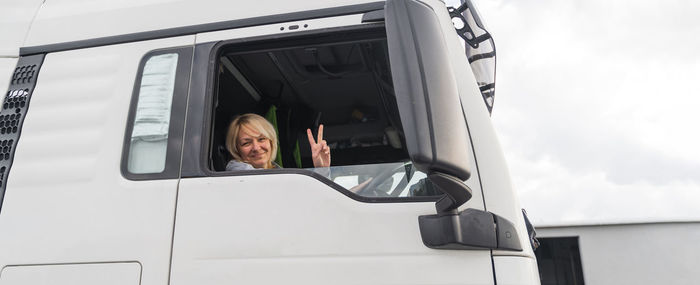 Caucasian mid age woman driving truck. trucker female worker, transport industry occupation