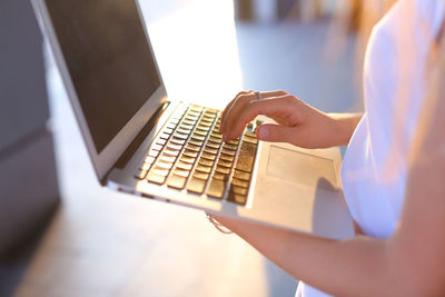 Midsection of woman using laptop