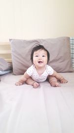 Portrait of cute girl lying on bed at home