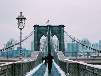 Rear view of people walking on suspension bridge