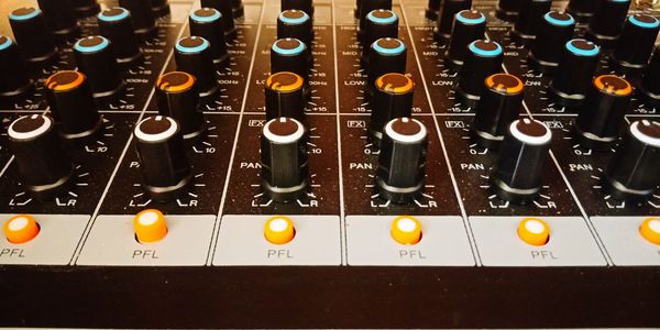 Close-up of analog audio mixer with funky colors