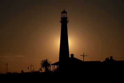 Low angle view of silhouette lighthouse against sky during sunset