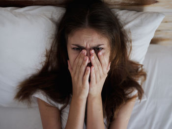 Portrait of woman lying down on bed at home