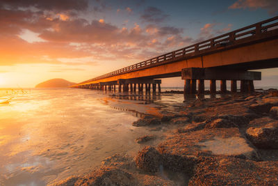 Bridge over sea against sky during sunset