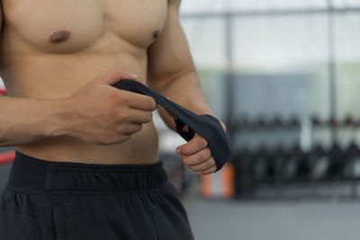 Close-up of shirtless man holding mobile phone