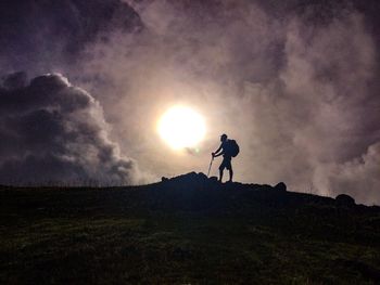 Silhouette man standing on field against sky