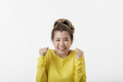 Portrait of smiling woman standing against white background