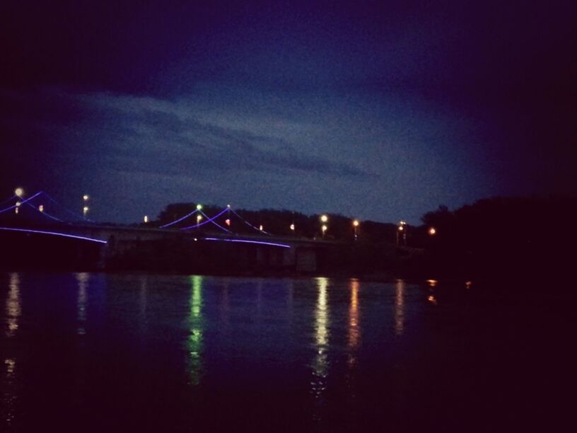 water, illuminated, night, reflection, sky, waterfront, river, lake, dusk, built structure, building exterior, tranquility, architecture, outdoors, transportation, cloud - sky, nature, silhouette, tranquil scene, scenics