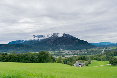 Scenic view of field and mountains against sky
