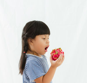 Girl holding ice cream cone against white background