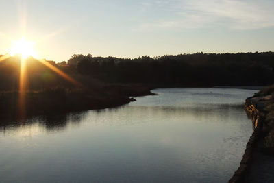 Scenic view of river against sky at sunset