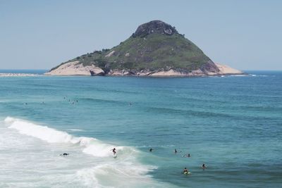 People enjoying at macumba beach against clear sky