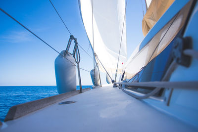 Close-up of sailboat sailing on sea against sky