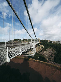 Bridge over river against cloudy sky