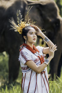 Portrait of smiling young woman standing on field