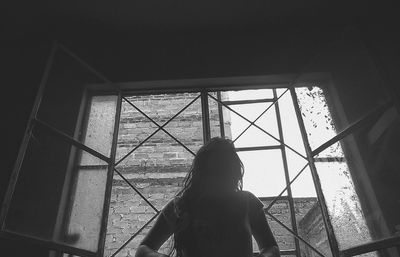 Low angle view of silhouette woman standing by window