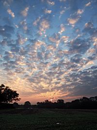 Scenic view of field against cloudy sky