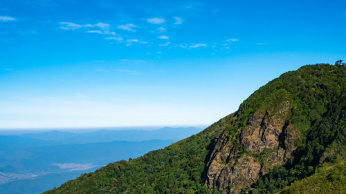 Scenic view of mountains against blue sky