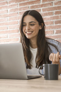 Young woman using laptop while sitting at home