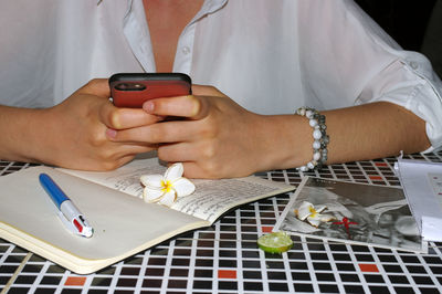 Midsection of woman using mobile phone