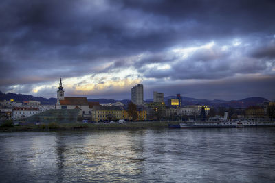 River by city against sky at dusk