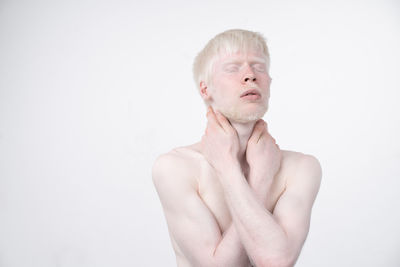 Portrait of shirtless young man against white background