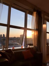 View of city through window at sunset