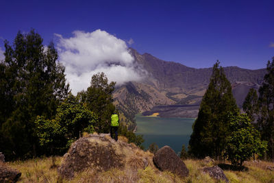 Scenic view of lake and mountains against blue sky