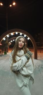 Portrait of woman standing in snow at night