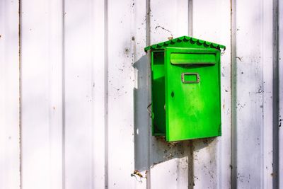 Close-up of mailbox on green wall