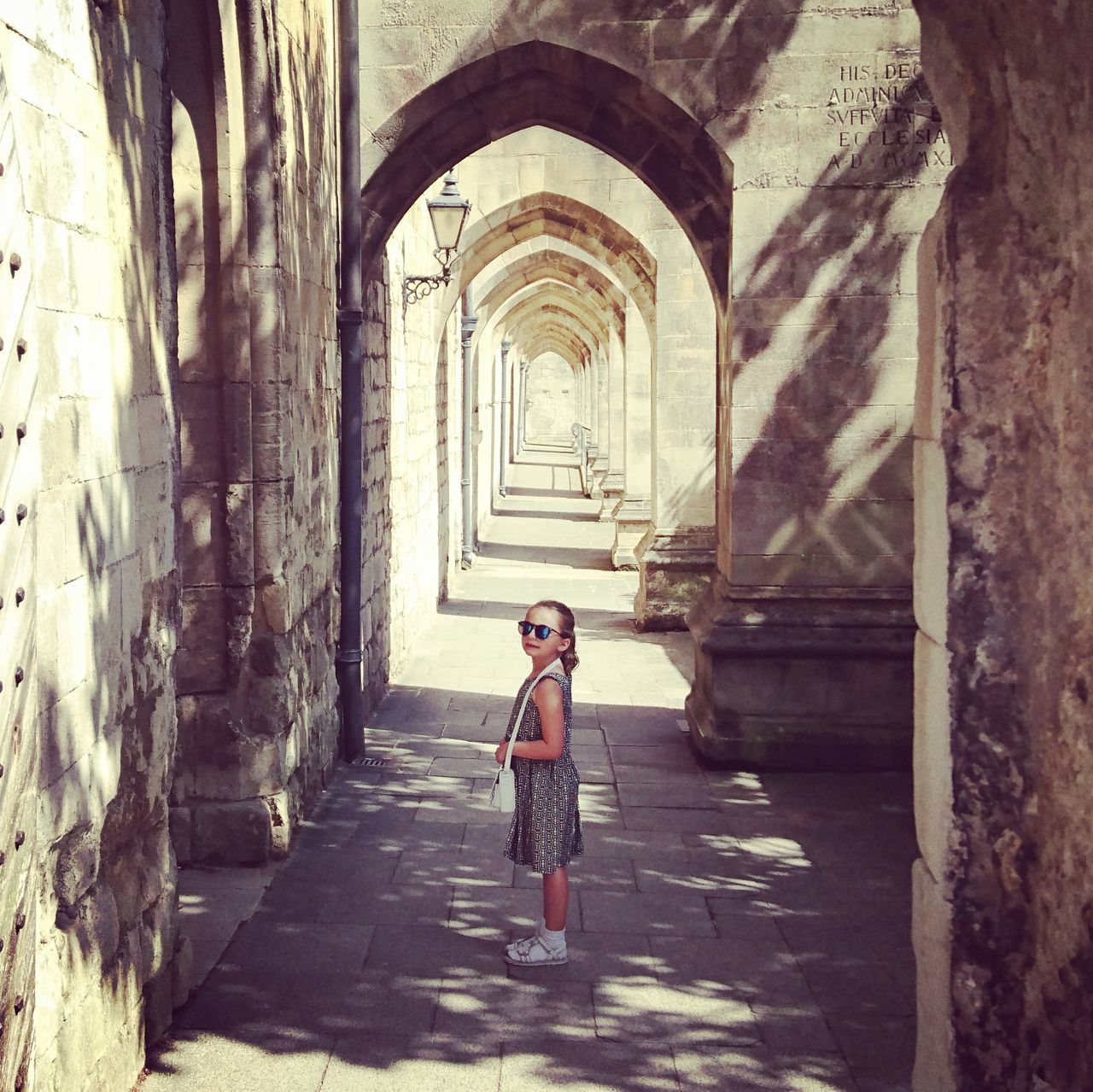 full length, arch, architecture, lifestyles, built structure, leisure activity, young adult, casual clothing, portrait, looking at camera, person, the way forward, young women, indoors, corridor, day, tourist, historic, archway, diminishing perspective, history, innocence