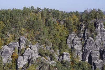 Panoramic view of rocks and trees against sky