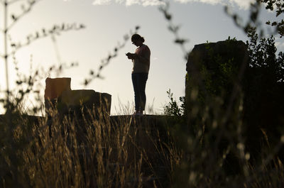 Rear view of silhouette man standing on field against sky