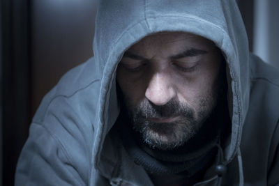 Close-up of depressed mature man wearing hooded shirt