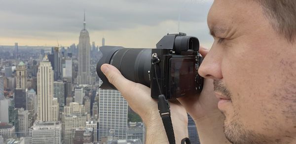 Portrait of man photographing cityscape