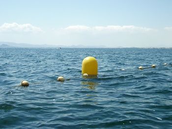 Yellow marine buoy and net blue sea