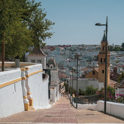 Footpath amidst buildings in town against sky